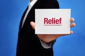 Relief. Lawyer in a suit holds card at the camera. The term Relief is in the sign. Concept for law,...