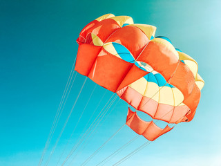 A multi-colored dome of a parachute in the sky as a background.