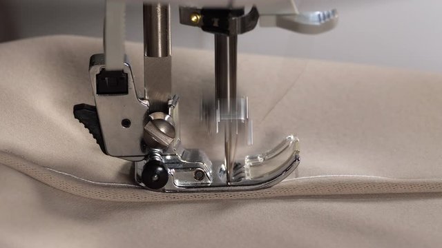Sewing machine needle fast motion. Macro of sewing machine mechanism. Sewing fabric by sewing machine, close up. 4K