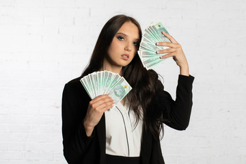Businesswoman holds Polish banknotes in a fan-shaped hands.