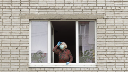Fototapeta na wymiar Old woman grandmother stay at window isolated at home on quarantine. Coronavirus