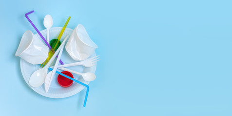 Plastic waste, plastic utensils on a blue background,flat lay. Say no to single use plastic. Ecology environmental care.Banner.Copy space for text.