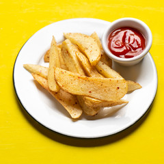 French fries with ketchup sauce on yellow background
