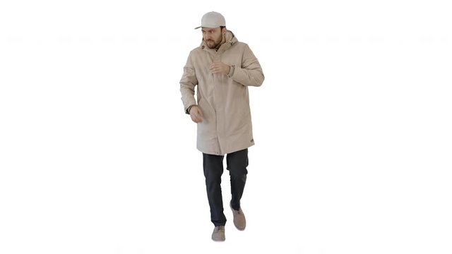 Man in winter outfit walking and coughing on white background.