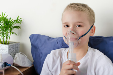 Sick boy breathing through nebulizer, inhaler for treatment prevention, such as coronavirus,...