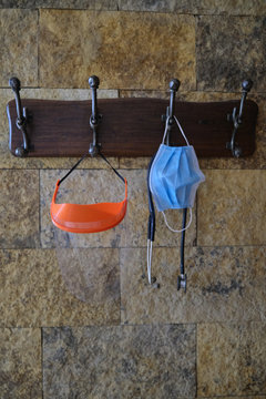 face mask or surgical chinstrap, an stethoscope and a plastic face protector hanging