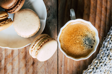 Macarons au chocolat et vanille et tasse de café expresso vu du dessus