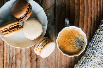 Macarons au chocolat et vanille et tasse de café expresso vu du dessus