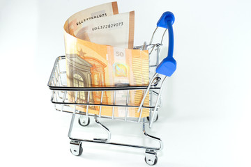 Money dollars and euros in a shopping trolley on a white background
