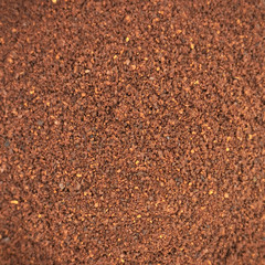 
ground coffee is scattered all over the background with soft focus