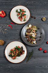 set of fresh salad and grilled steak on grey served table. traditional dish menu served in a restaurant