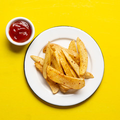 French fries with ketchup sauce on yellow background