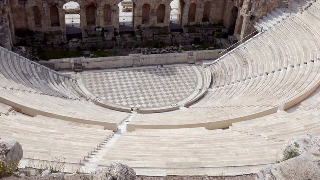 Tilt up over remaining of the Odeon of Herodes Atticus stone Roman theater structure inside Acropolis of Athens 