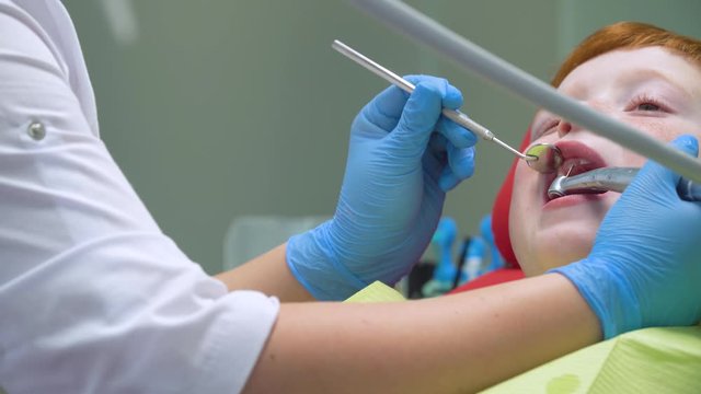 A little boy having a teeth cleaning treatment in the dentistry . Pediatric dentistry