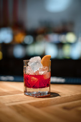 red alcohol cocktail on dark bar