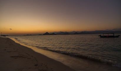 Colorful vivid sunset or sunrise scene at remote island coast with a many hills and mountains in Sumbawa