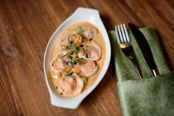 Shrimp raviolli served on wooden table