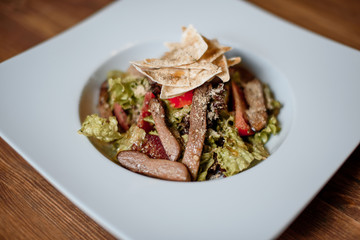 grilled meat with fresh salad on grey served table. traditional dish menu served in a restaurant