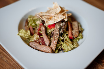 grilled meat with fresh salad on grey served table. traditional dish menu served in a restaurant