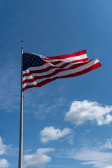 USA Flag flying against a blue sky.