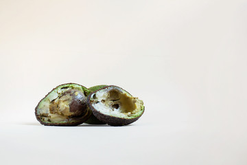 Bad avocado close - up on a white background. Concept for dealing with missing tropical products