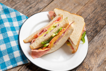 Ham sandwich with cheese on wooden background