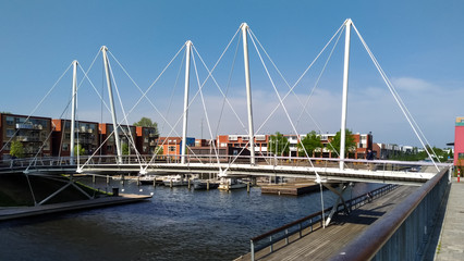 Fototapeta premium Almere, Netherlands - April 22 2019: Pedestrian bridge over a canal