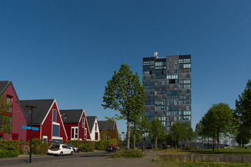 Nice red houses in a residential area, next to a tall office building