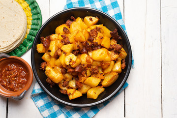 Mexican potatoes with chorizo on white background