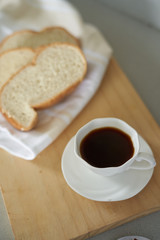 Small white cup of coffee and bread