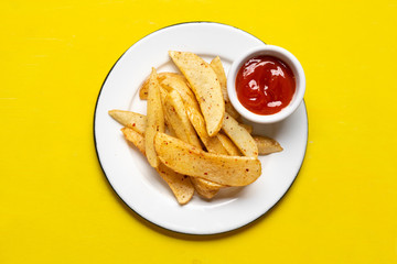 French fries with ketchup sauce on yellow background