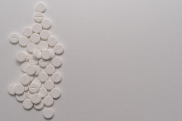 White tablets scattered on a white background