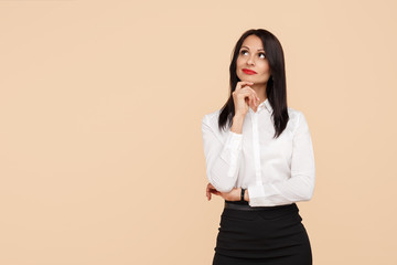 Confident strategic young modern business woman think looking up over beige background.