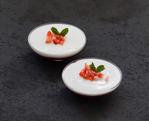 Italian creamy berry dessert Panna cotta vanilla with strawberries in a glass bowl on a dark background