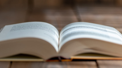 A thick book with open hardcover on a wooden floor