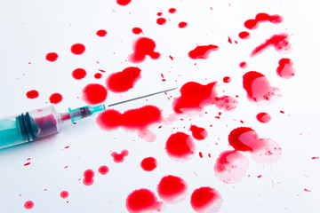 Syringe with blood, a lot of drops of blood
