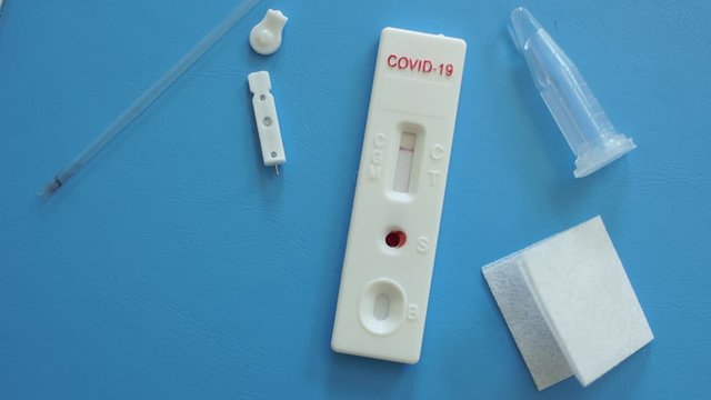 Close up of a doctors hand lays on the table a used test cassette express test covid-19. The work of the laboratory during the coronavirus pandemic. Commercial and state laboratories
