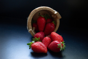 an overturned wooden basket with scattered trawberries