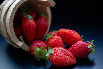 an overturned wooden basket with scattered trawberries