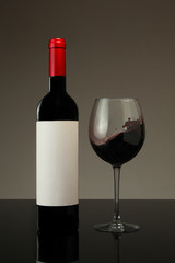 Garrafa de vinho e copo fotografados  em estudio 