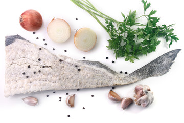 dry salted raw cod isolated over white background, accompanied by pepper, onion, garlic, parsley, spices