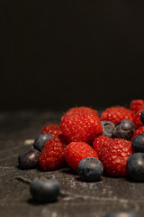 Close-up of berries (blueberries, raspberries) on a dark background.