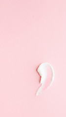 White smear and texture made by cream isolated on pink background.

