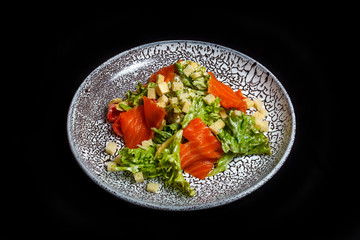 Juicy delicious salad of red fish, lettuce, bread crumbs, boiled eggs in balsamic sauce. Black background