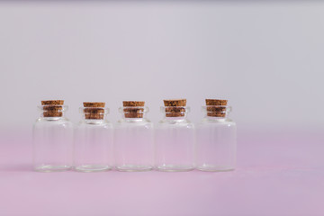 skincare and beauty, group of essential oil bottles on pink and white muted background with minimalist composition
