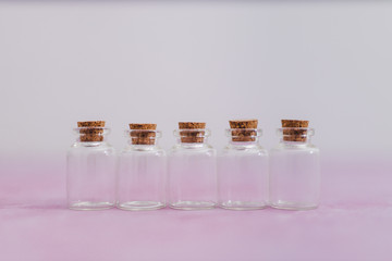 skincare and beauty, group of essential oil bottles on pink and white muted background with minimalist composition
