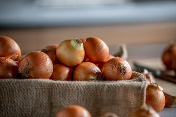 Fresh ripe onions on table in kitchen.