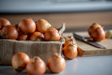 Fresh ripe onions on table in kitchen.