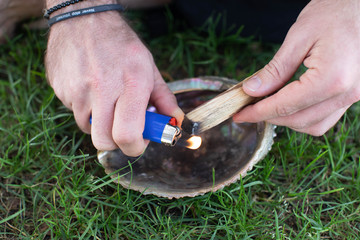 man lighting palo santo