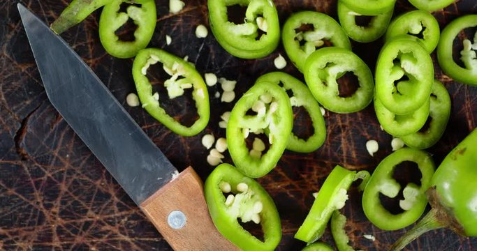 Slices green hot chili pepper slowly rotate.